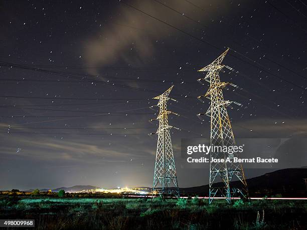 towers and electrical cables of high tension in the night - maquinaria ストックフォトと画像