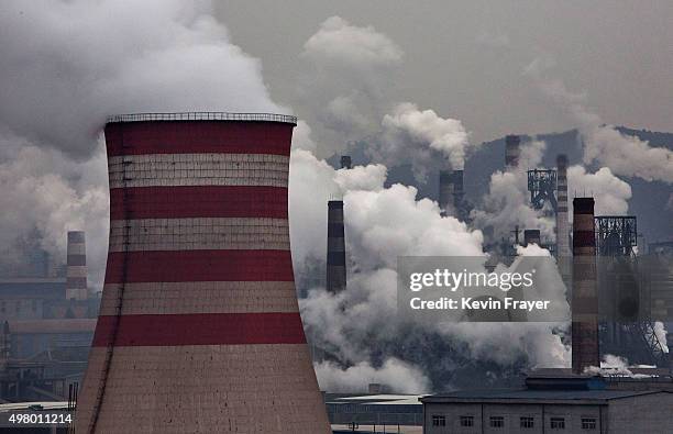 Smoke billows from smokestacks and a coal fired generator at a steel factory on November 19, 2015 in the industrial province of Hebei, China. China's...