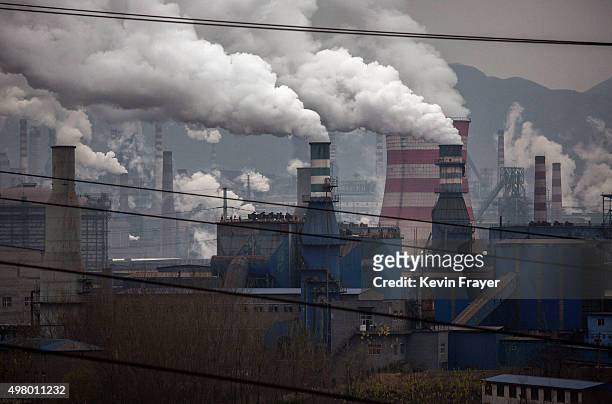 Smoke billows from smokestacks and a coal fired generator at a steel factory on November 19, 2015 in the industrial province of Hebei, China. China's...