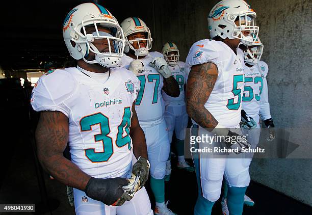Damien Williams, Billy Turner and Mike Pouncey of the Miami Dolphins walk out of the tunnel before a football game against the Philadelphia Eagles at...