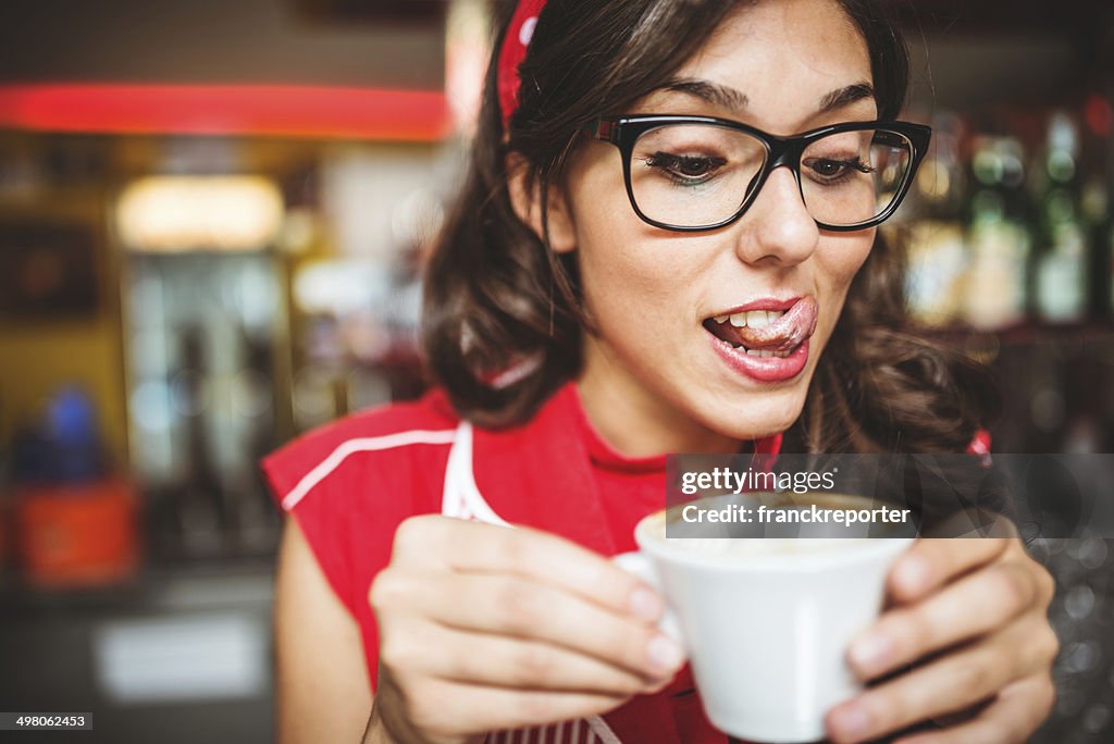 Woman eating a cappuccino at cafè