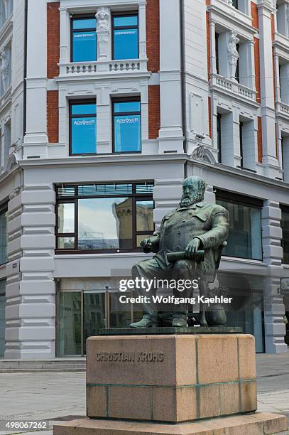 Karl Johans Gate street scene in Oslo, Norway with the statue of Christian Krohg, a Norwegian naturalist painter, illustrator, author and journalist.