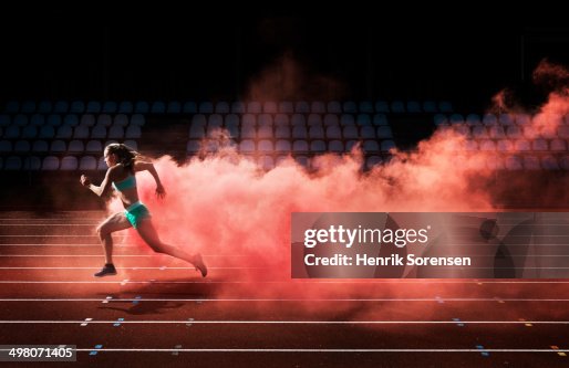 Athlete running in red smoke Athlete running in red smoke