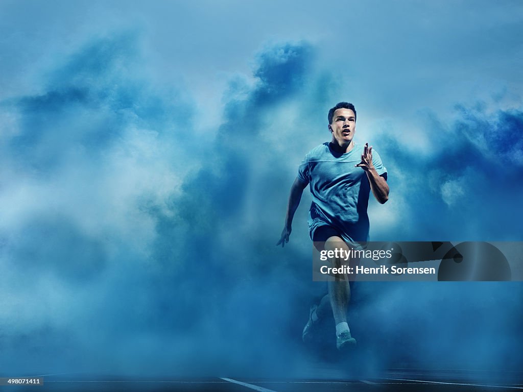 Athlete running in blue smoke