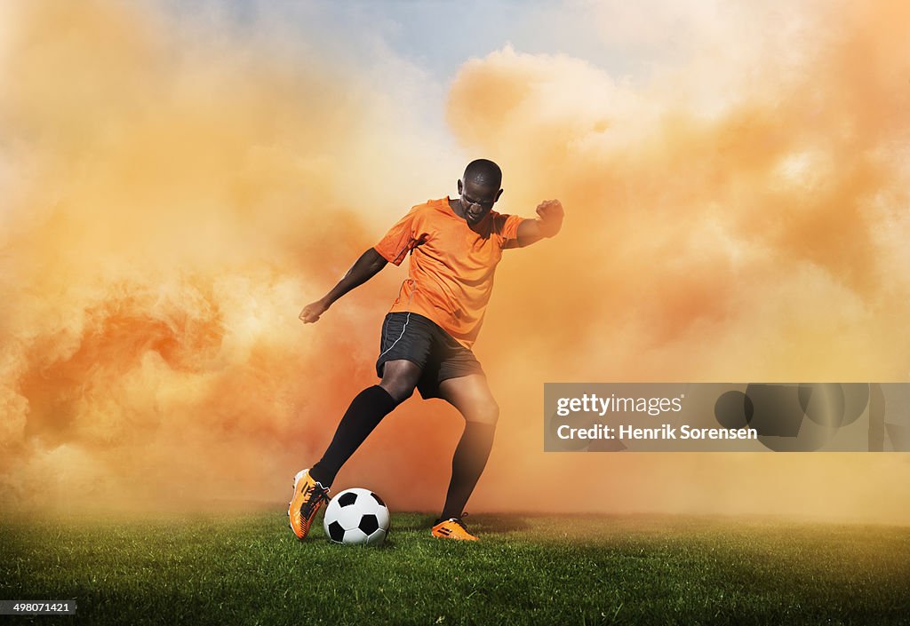 Football player in orange smoke