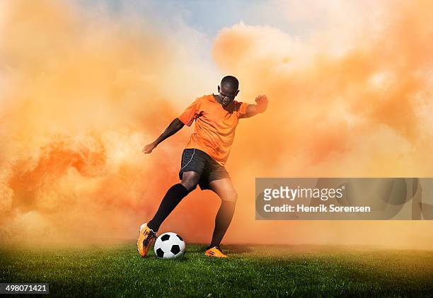 football player in orange smoke - football player stock pictures, royalty-free photos & images