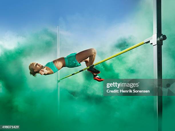 athlete jumping high jump in smoke - stavhopp bildbanksfoton och bilder