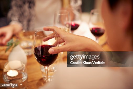 Close-up of female holding glass with redwine Close-up of female holding glass with redwine