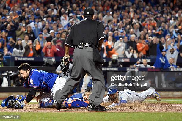 Eric Hosmer of the Kansas City Royals slides safely into home to score the game tying run as Travis d'Arnaud of the New York Mets attempts to catch...