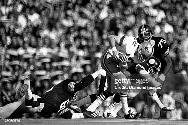 Quarterback Roger Staubach of Dallas Cowboys runs out of the pressure of defensive lineman L.C. Greenwood, Dwight White, and Joe Greene of the...