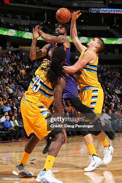 Markieff Morris of the Phoenix Suns is fouled by Nikola Jokic of the Denver Nuggets as Kenneth Faried of the Denver Nuggets follows the play at Pepsi...