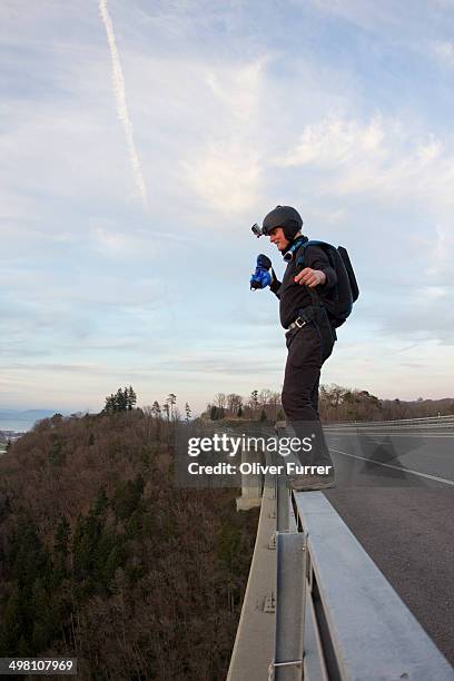 a base jumper is ready to jump from a bridge - base jumping stock pictures, royalty-free photos & images