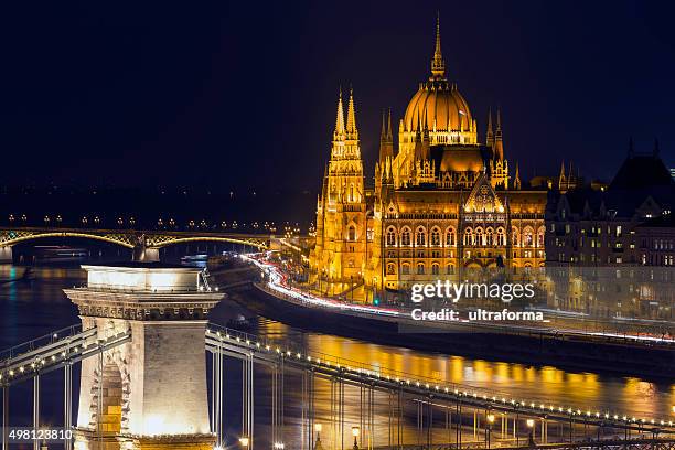 blick auf die kettenbrücke und das parlament in budapest in der dämmerung - chain bridge suspension bridge stock-fotos und bilder