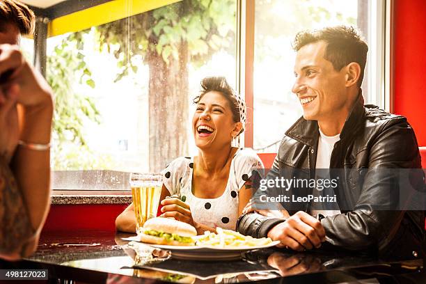 friends enjoy together dinner in a cafe - 50s rockabilly men stock pictures, royalty-free photos & images