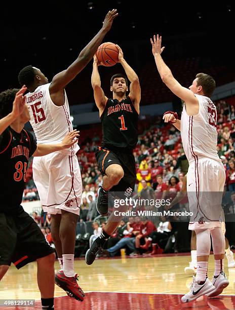 Geno Luzcando of the Idaho State Bengals goes to the basket between Junior Longrus and Brett Boese of the Washington State Cougars in the second half...