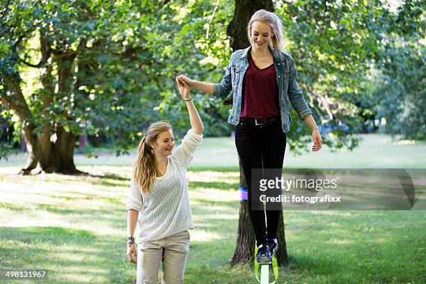 teenager-mädchen im park und balancierst auf einem locker line - tightrope walking stock-fotos und bilder