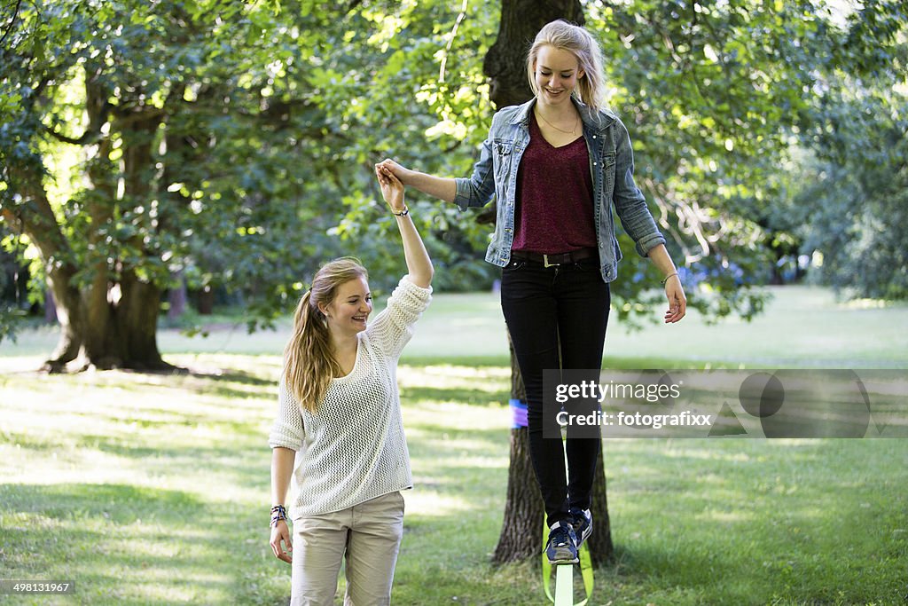Menina adolescente no Parque equilíbrio sobre uma folga linha