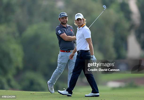Andy Sullivan of England plays his second shot on the par 4, third hole as his playing partner Emiliano Grillo of Argentina walks past during the...