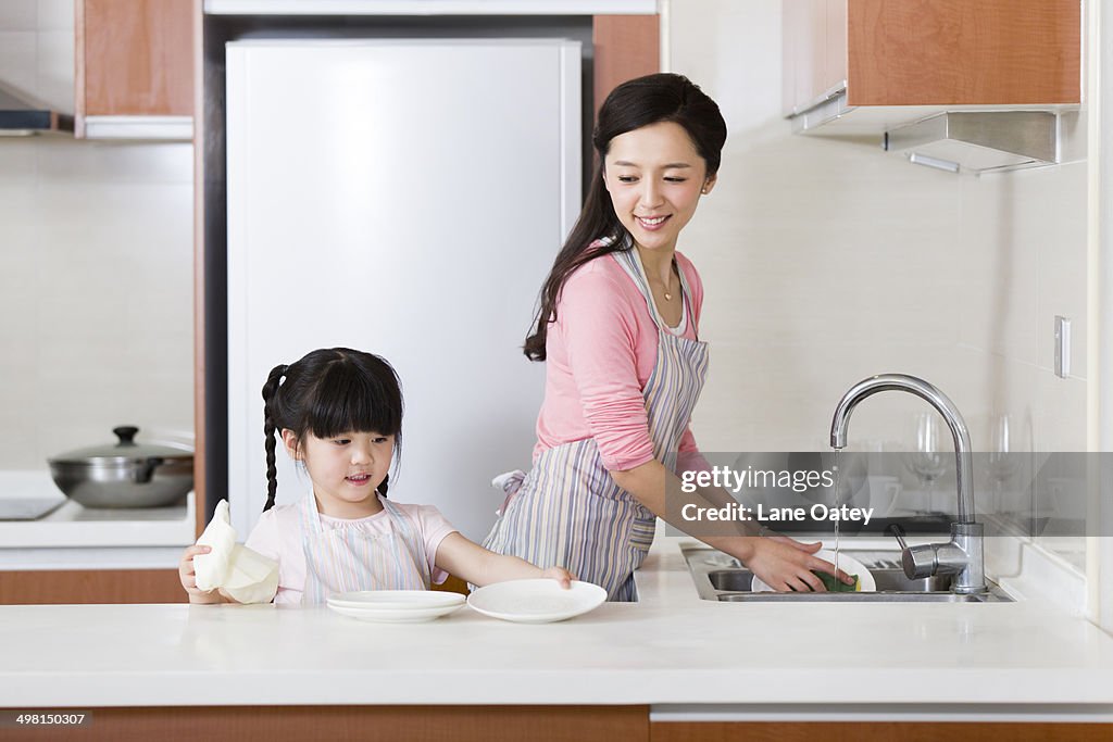 Mother and daughter washing dishes