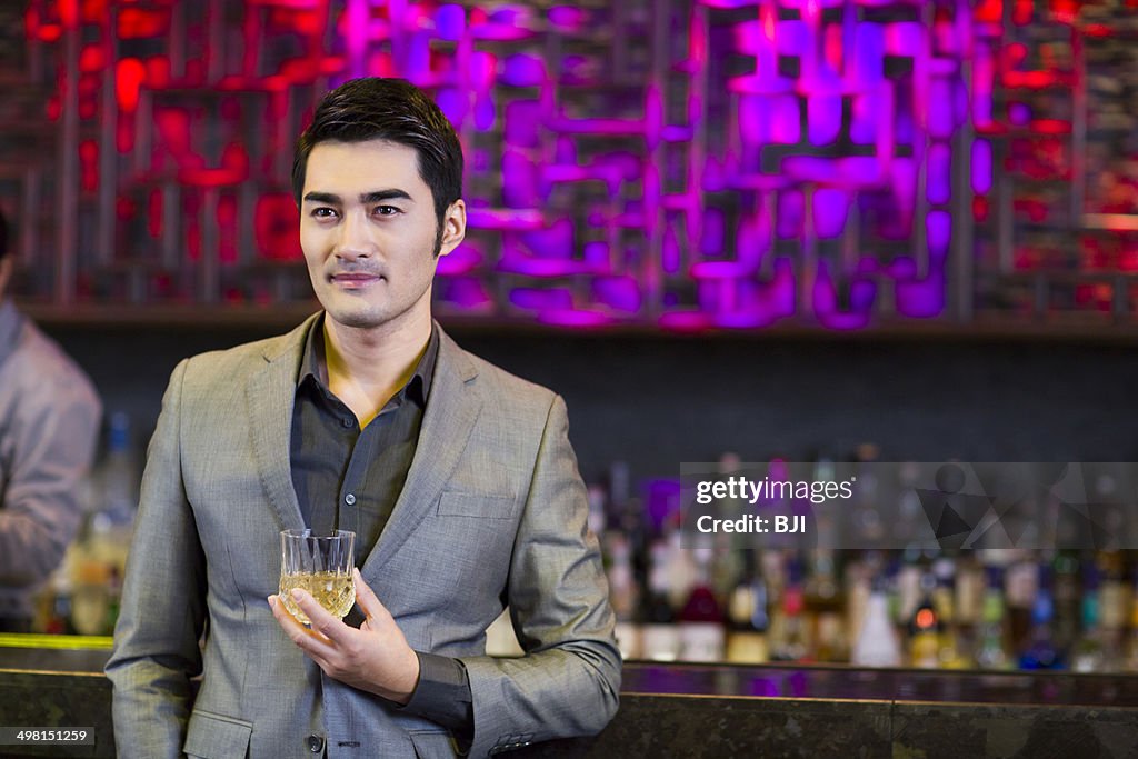 Young man having a drink at bar