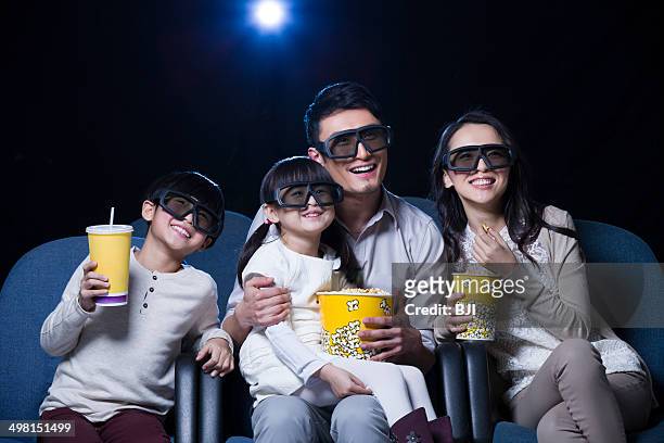 young family watching 3d movie in cinema - mamã filme de 2013 imagens e fotografias de stock