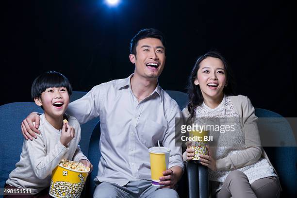 young family watching movie in cinema - mamã filme de 2013 imagens e fotografias de stock