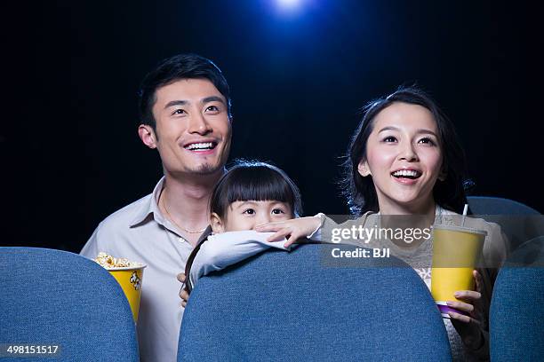 young family watching movie in cinema - asian cinema stock pictures, royalty-free photos & images