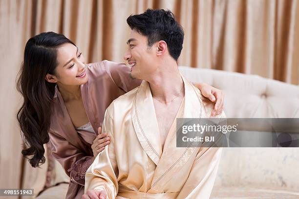 happy young couple in bedroom - silk nighty stockfoto's en -beelden