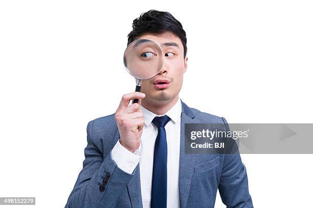Young Businessman Looking Through Magnifying Glass, Foto de stock
