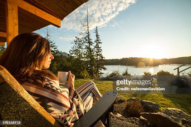young woman in the morning watching sunrise and drinking tea - terrace british columbia stock pictures, royalty-free photos & images
