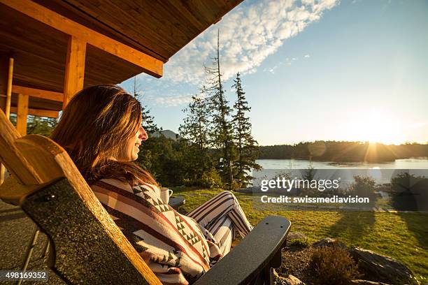 young woman relaxing and watching sunrise - terrace british columbia stock pictures, royalty-free photos & images