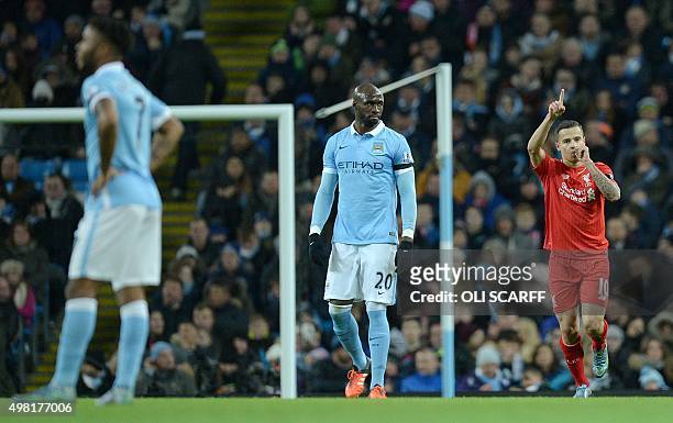 Manchester City's French defender Eliaquim Mangala looks on as Liverpool's Brazilian midfielder Philippe Coutinho celebrates after scoring their...