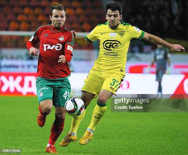 Roman Shishkin of FC Lokomotiv Moscow challenged by Batraz Khadartsev of FC Anzhi Makhachkala during the Russian Premier League match between FC...