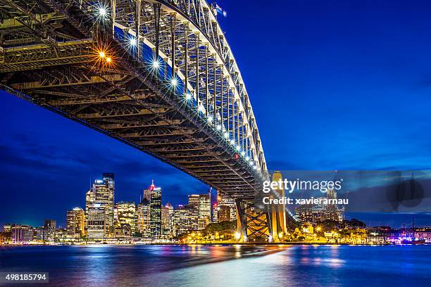 sydney harbour bridge with downtown in the background at dusk - sydney harbour bridge night stock pictures, royalty-free photos & images