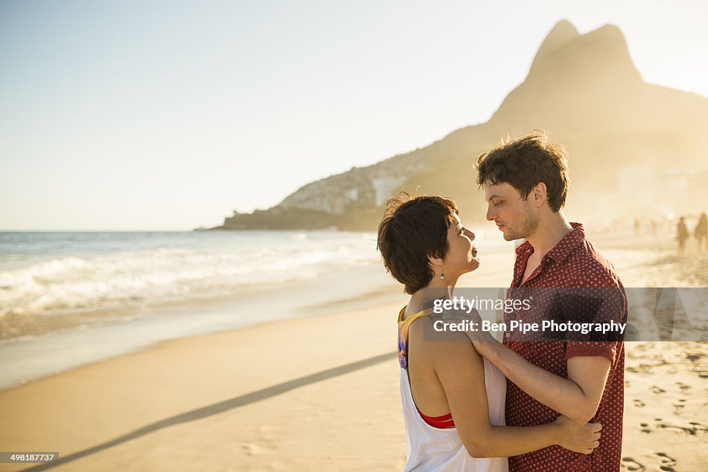 Young couple hugging at sunset, Ipanema Beach, Rio, Brazil