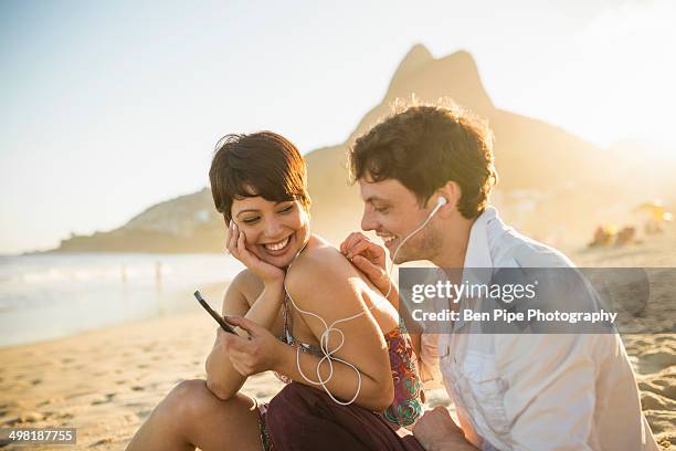 young couple listening to music, ipanema beach, rio, brazil - zomer muziek stockfoto's en -beelden