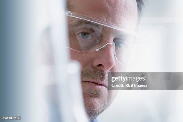 scientist wearing protective goggles, close-up - arbeitskleidung portrait close stock-fotos und bilder