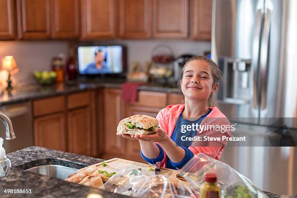 girl in kitchen preparing sandwich - een broodje smeren stockfoto's en -beelden