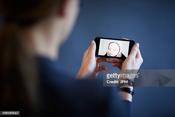 working mother having video call with son on smartphone - horizontal stock-fotos und bilder