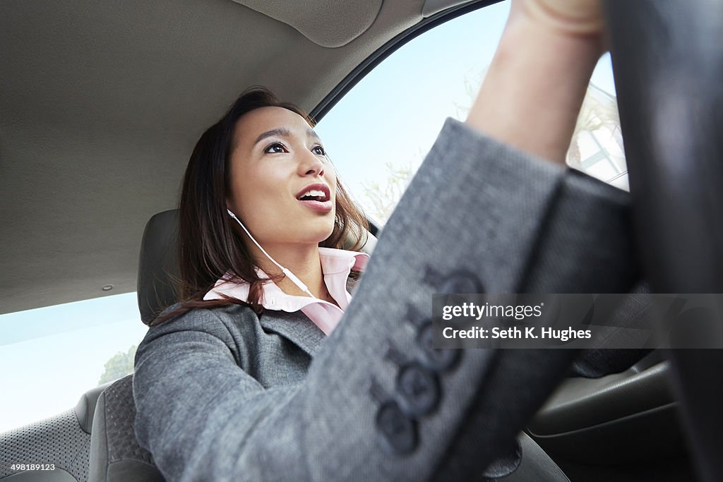 Young female businesswoman driving car