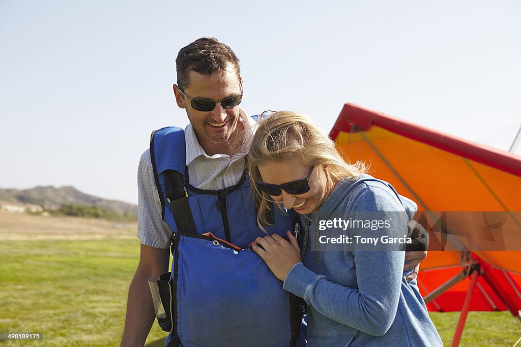 Happy couple, hang glider in background
