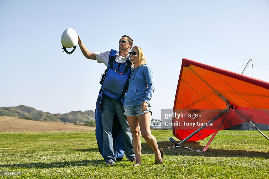 Couple enjoying view, hang glider in background