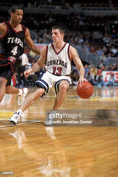 Matt Santangelo of the Gonzaga Bulldogs dribbles the ball as he is coverd by Lynn Green of the Temple Owls during the Great Eight game at the United...