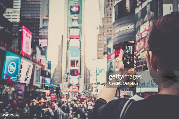 woman taking picture with mobile phone at times squares, nyc - new years eve new york city stock pictures, royalty-free photos & images