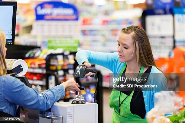 supermarket cashier scanning smart phone to accept payment - retail loyalty stock pictures, royalty-free photos & images