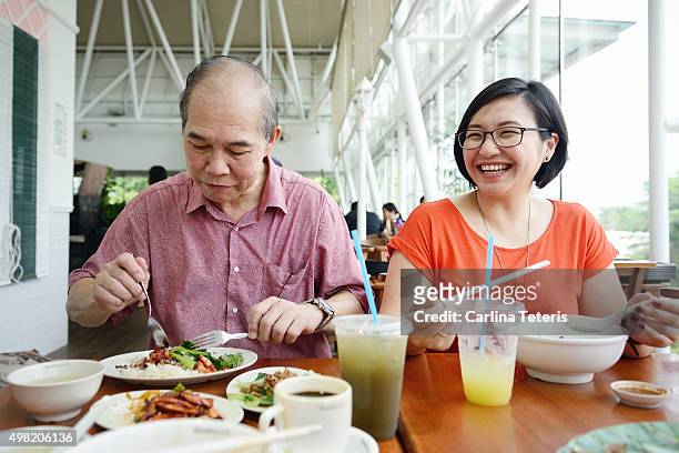 asian lady and mature man having a meal together - food court stock pictures, royalty-free photos & images