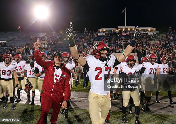 Dan Melow of the Harvard Crimson leads the team onto the field after defeating the Yale Bulldogs, 38-19 on November 21, 2015 in New Haven,...