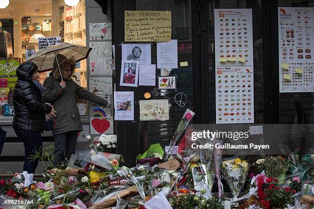 People look at the memorial in "La Belle Equipe" restaurant and a Japanese restaurant in the 11th district of Paris, following a series of...