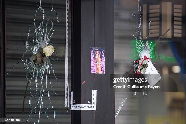 Flowers are left inside bullet hole through the glass of a Japanese restaurant next to "La Belle Equipe" restaurant in the 11th district of Paris,...