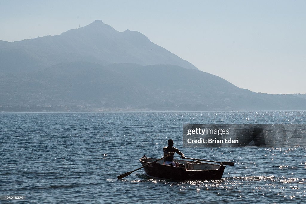 A man rowing a rowboat in Procida, Italy